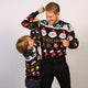 En mand og en dreng poserer sammen i sorte julesweatre.