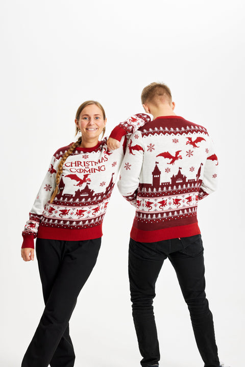 En mand og en dame iført en julesweater med citatet "Christimas is coming". Sweatrene har røde kraver og en rød bund. 