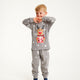 Et sødt barn poserer i sine flotte, grå julepyjamas.
