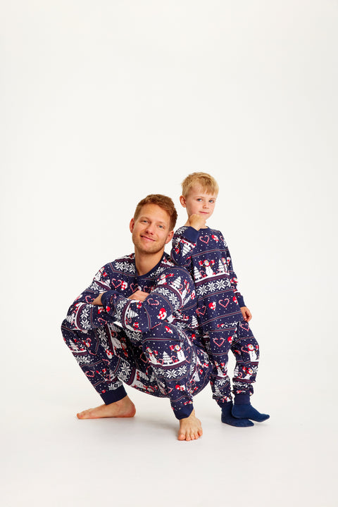 En mand og et barn poserer med blå julepyjamas på.