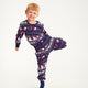 En legende barn med julepyjamas, der har mønster på.